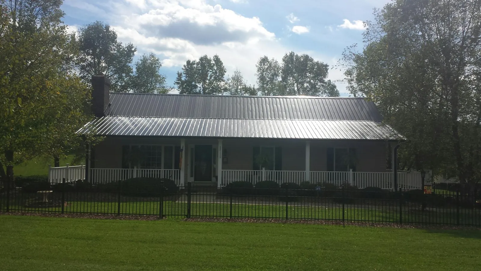 Gray metal roof on a brick ranch with a full width front porch — Gutter Guard Installation work by our crew in Obernburg
